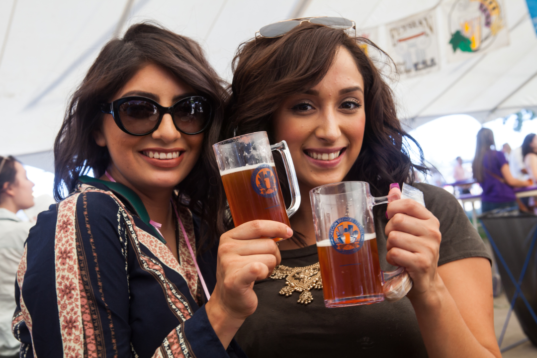 Two women enjoying beer in mugs.