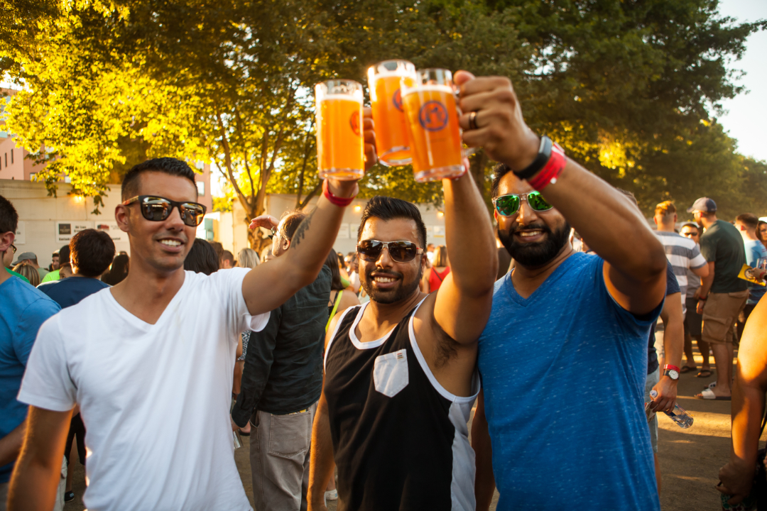 3 guys cheering with beer at the event.